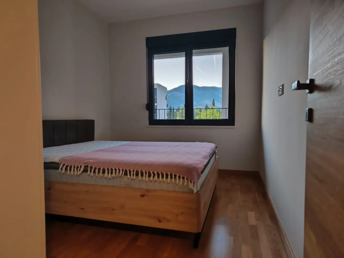 Bedroom with a double bed and a view of the mountains through the window.