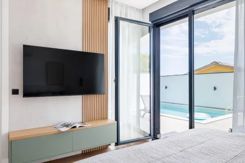 Modern bedroom with a view of the pool and access to the terrace. - image 12