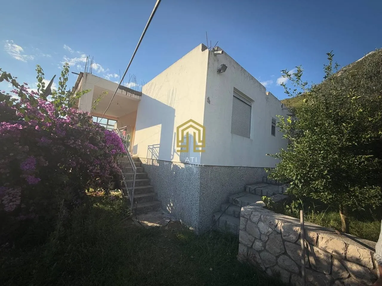 Spoljašnji izgled kuće sa dvorištem i stepeništem.