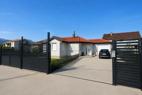 Pogled na spoljašnjost kuće sa uređenim dvorištem, ogradom i parkingom. - image 2