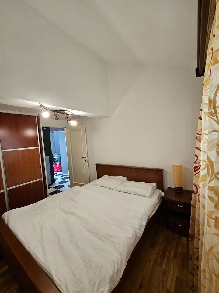 Furnished bedroom with a double bed, wardrobe, and a nightstand.