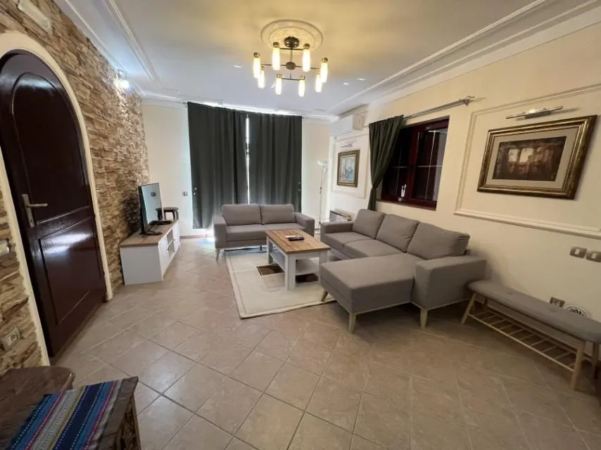 A bright living room with comfortable sofas and a decorative stone wall.