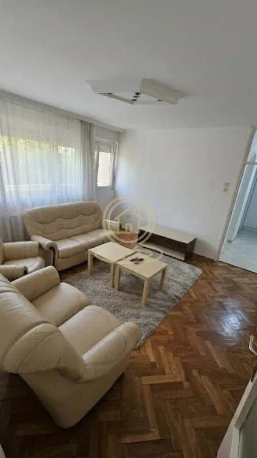 Living room with a sofa set, coffee table, and parquet flooring.