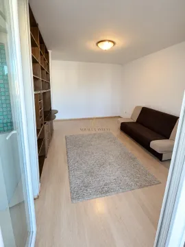 Living room with a sofa, rug, and built-in shelving. - image 3