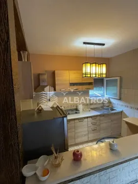 Smaller kitchen with wooden elements and a bar counter. - image 4