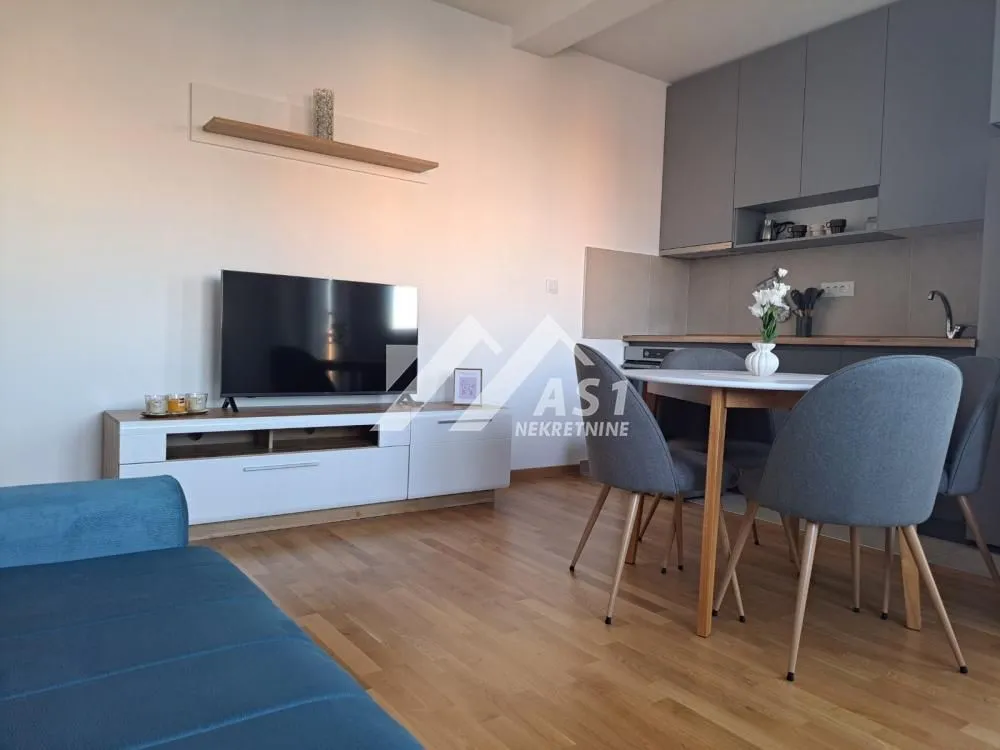 Living room with dining area and kitchen in an open space layout.