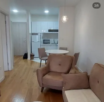 Living room with a dining area and a view of the kitchen. - image 2