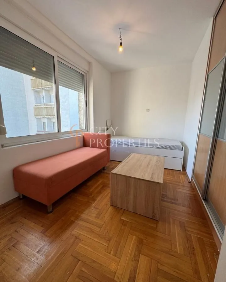 Small bedroom with a bed, wardrobe, and parquet flooring.