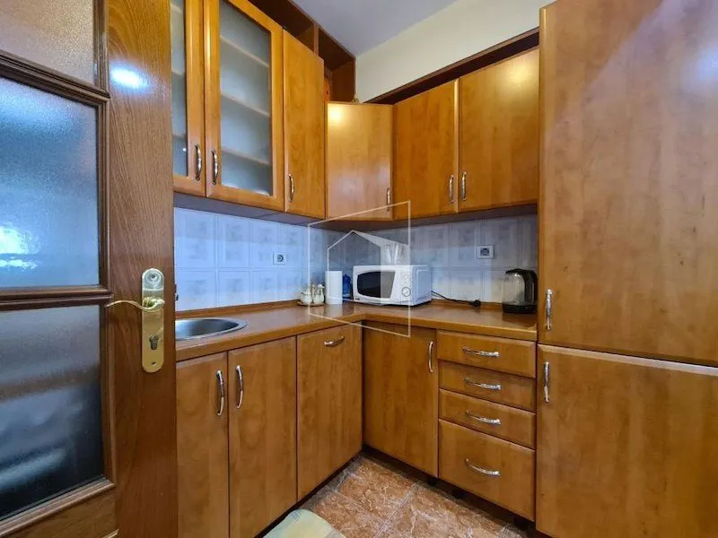 Smaller wooden kitchen with countertops and wall cabinets.
