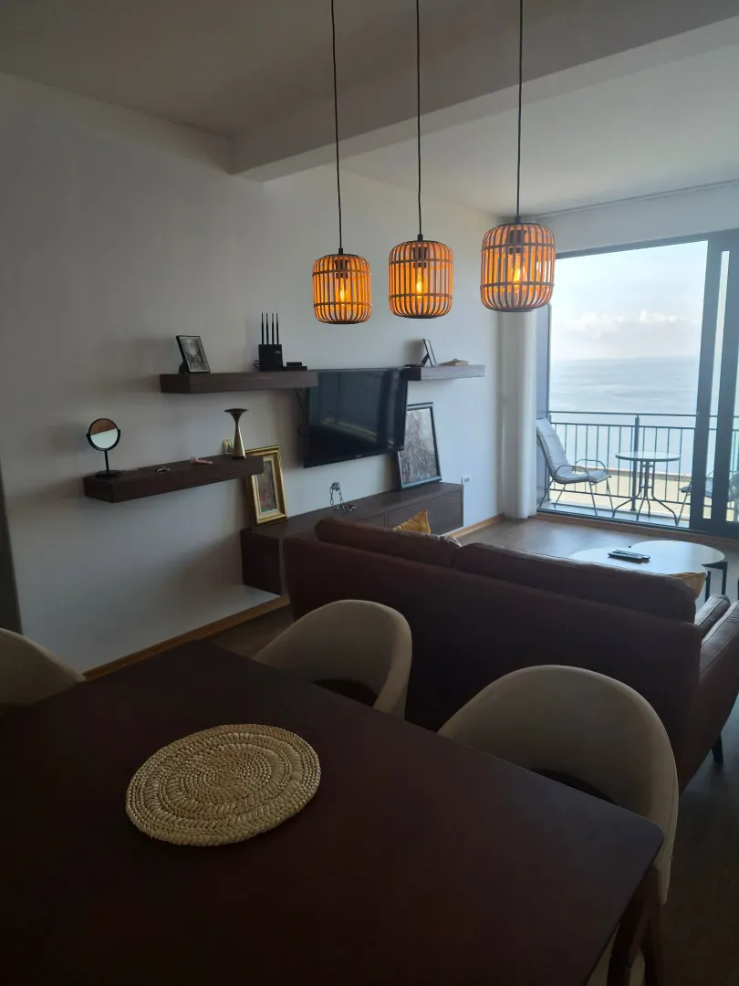 Living room with dining area and a sea view.