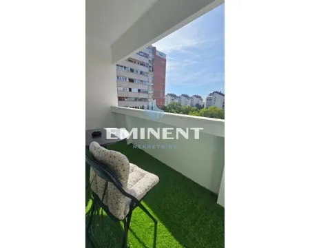 Small covered balcony with a chair and a view of surrounding buildings. - image 14