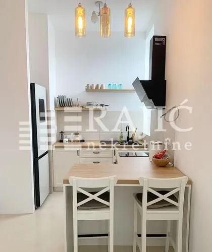 Small modern kitchen with a breakfast bar and dining chairs.