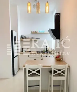 Small modern kitchen with a breakfast bar and dining chairs. - image 5
