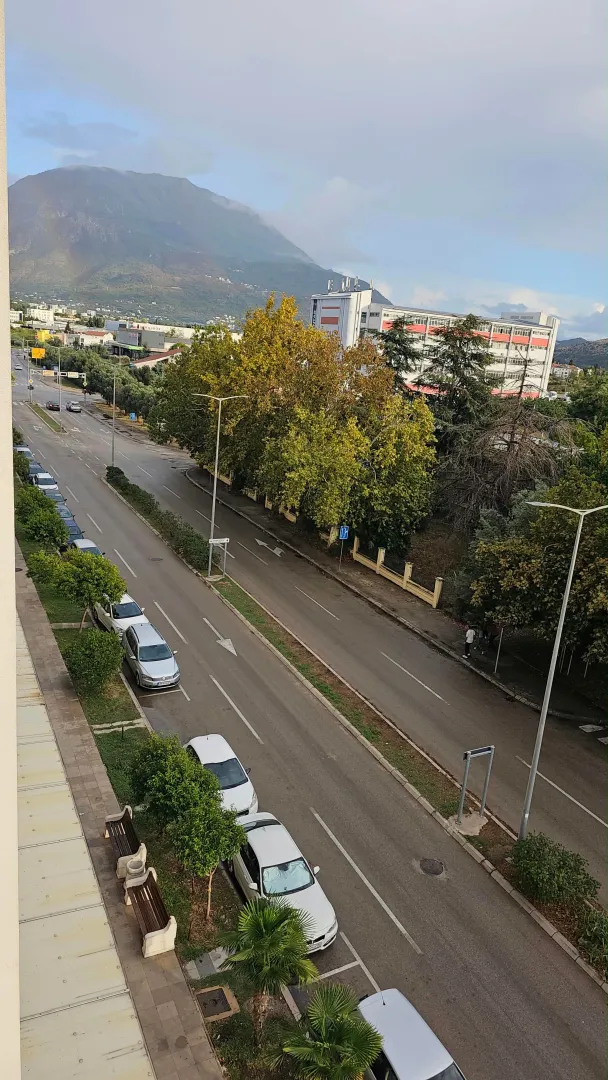 Pogled sa terase na ulicu i planine u pozadini.