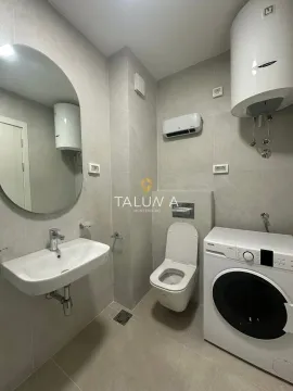 Moderno opremljeno kupatilo sa umivaonikom, toaletom i veš mašinom. - image 3