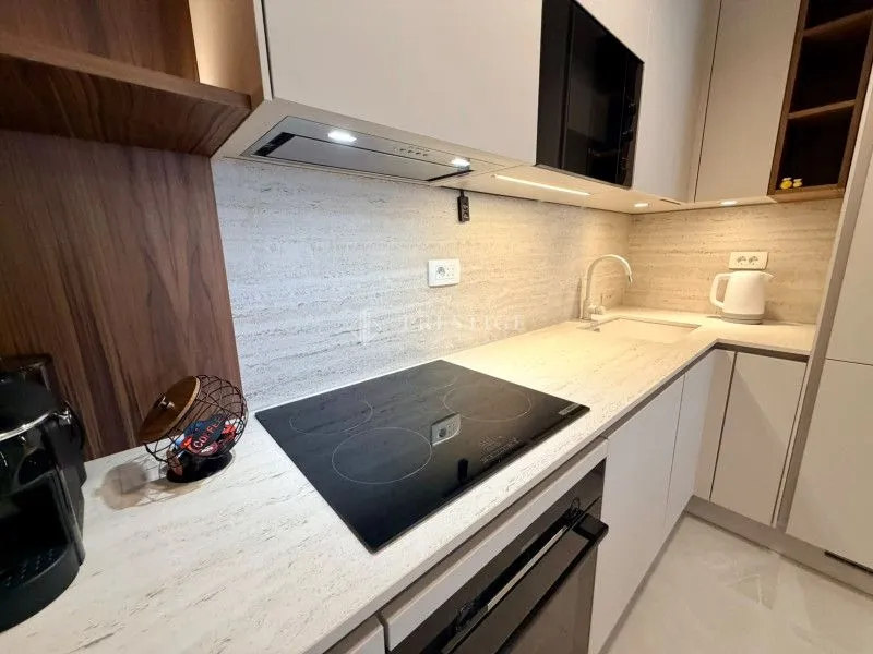 Modern kitchen with a built-in cooktop and white cabinetry.