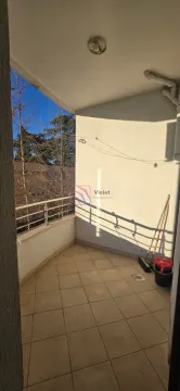 Nenamešten balkon sa pločicama i pogledom na okolne zgrade i drveće. - image 2