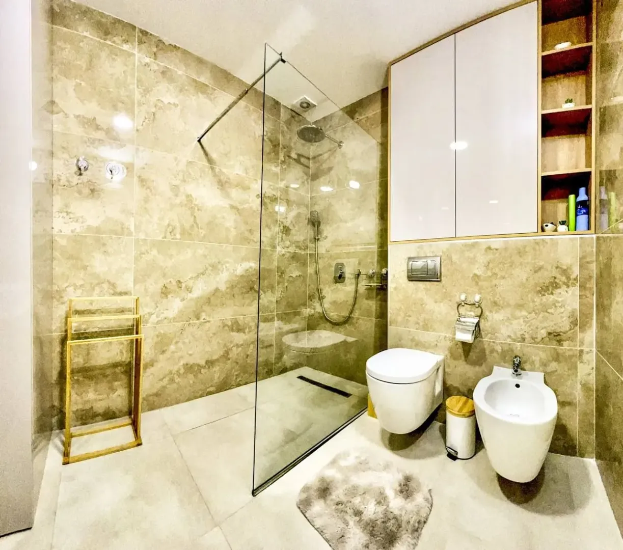 Modernly equipped bathroom with a walk-in shower, toilet and bidet.