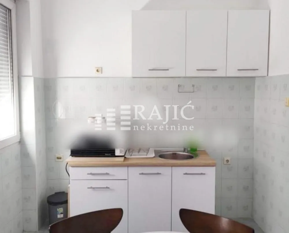 Small kitchen with white cabinets and a sink.