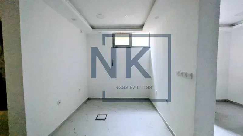 Empty unfurnished room with white walls and tiled flooring.