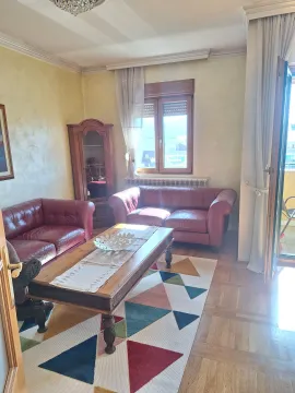 Living room with leather sofas, wooden table, and a display cabinet. - image 3