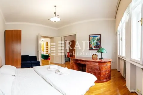 Spacious bedroom with a double bed, desk, and wooden flooring. - image 12