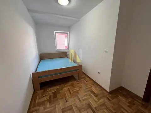 Manja spavaća soba sa krevetom i parketom na podu. - image 6