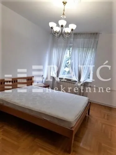 Bedroom with a double bed, parquet flooring, and a window.