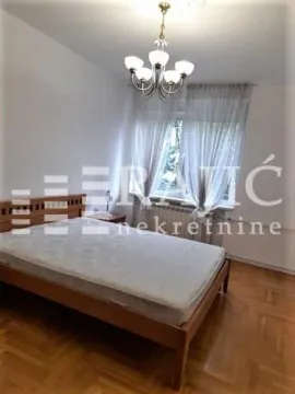 Bedroom with a double bed, parquet flooring, and a window. - image 2