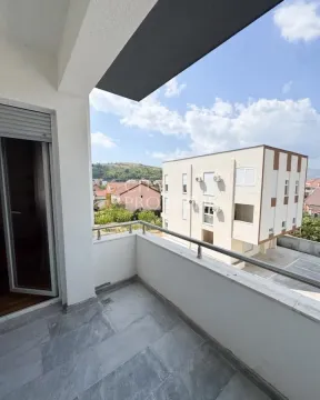 Natkriveni balkon sa pogledom na okolne zgrade i brda. - image 8