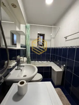 Smaller bathroom with a bathtub, washbasin, and white tiles. - image 11