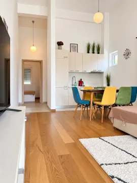 Living room with dining area and kitchen in bright tones. - image 2