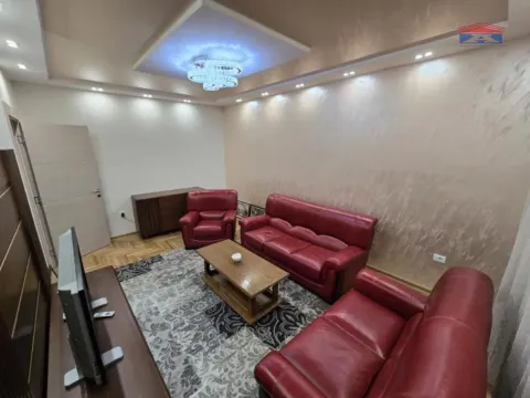 Living room with a red leather sofa set and coffee table. - image 11