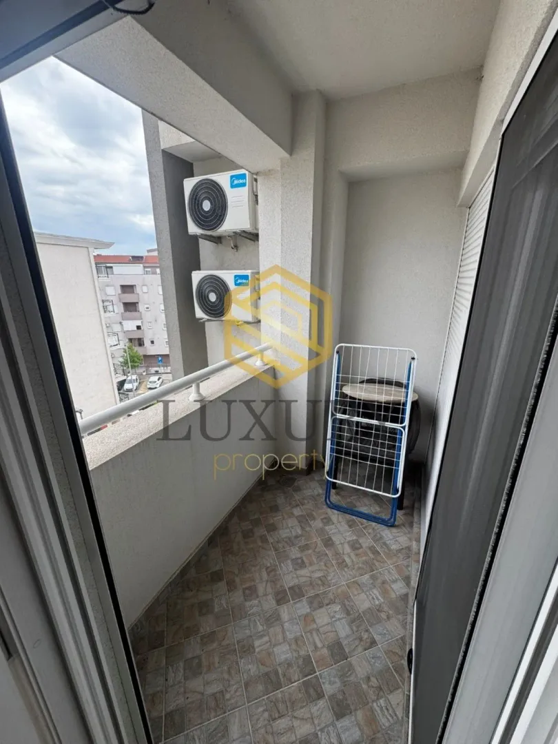 Smaller covered balcony with ceramic tiles and air conditioning units.