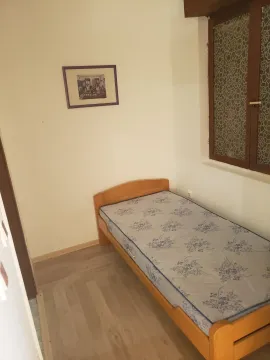 A small bedroom with white walls and a single bed. - image 3