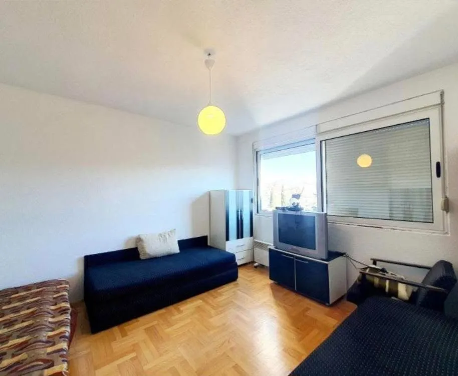 Living room with a sofa, TV, and a window.
