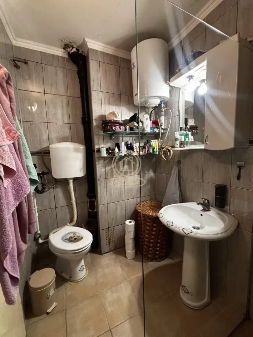 Manje kupatilo sa tuš kabinom, umivaonikom, WC šoljom i bojlerom.