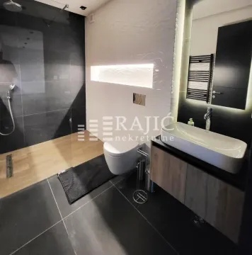 Moderno opremljeno kupatilo sa tuš kabinom i umivaonikom. - image 3