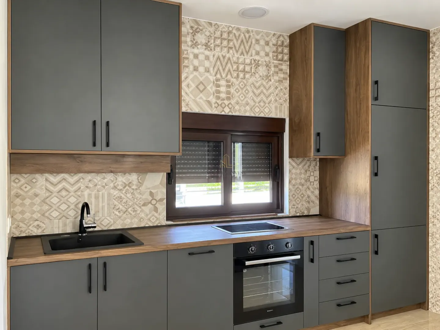 Modern kitchen with grey cabinets and a built-in oven.