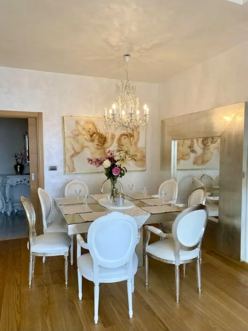 Dining room with dining table, chairs, and chandelier.