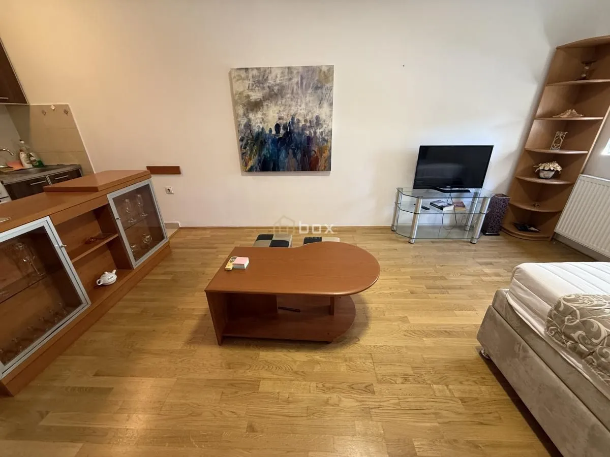 Living room with wooden furniture, a television, and parquet flooring.