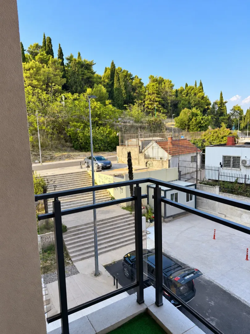 View from the terrace overlooking surrounding greenery and parking.