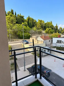 View from the terrace overlooking surrounding greenery and parking. - image 4