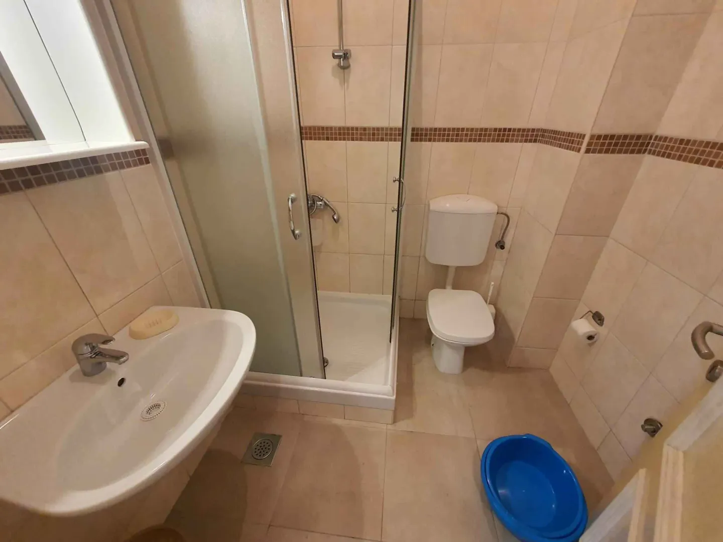 Kupatilo opremljeno tuš kabinom, umivaonikom i wc šoljom.