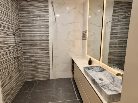 Modern bathroom with walk-in shower and marble washbasin. - image 3