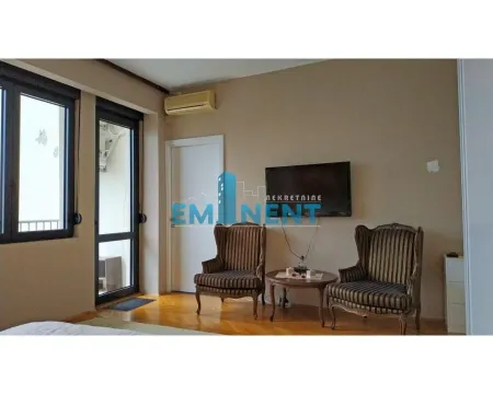 Living room with two armchairs, a coffee table, and a wall-mounted TV. - image 9