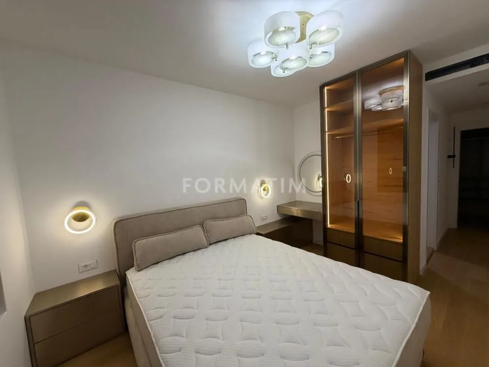 Furnished bedroom with a double bed, wardrobe, and lighting.