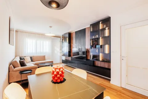 Modern living room with a sofa, dining table, and built-in furniture. - image 2