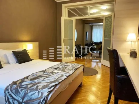Furnished bedroom with a double bed and a desk. - image 2