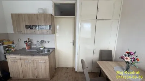 Manja kuhinja sa drvenim elementima i trpezarijskim stolom. - image 3